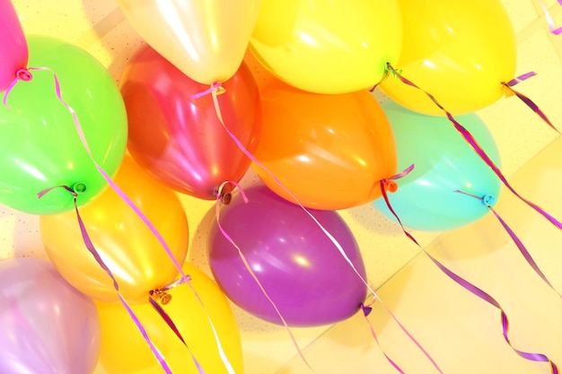 Many bright balloons under ceiling closeup