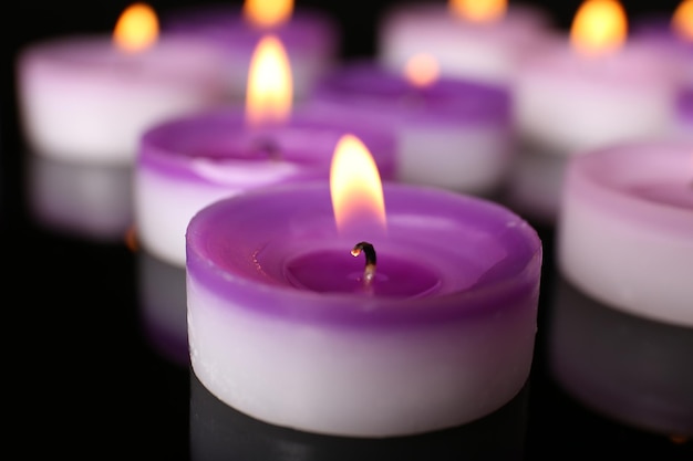 Many burning small candles on dark background closeup