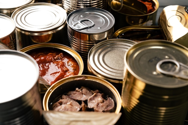 Many cans with conserved fish on wooden table