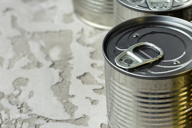 Many cans with meals such as meat and fish on the table, conserved food, close up