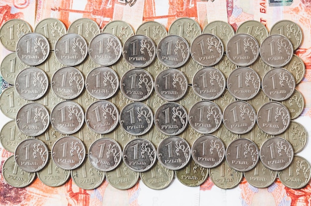 Many coins of 1 ruble lie on Russian money