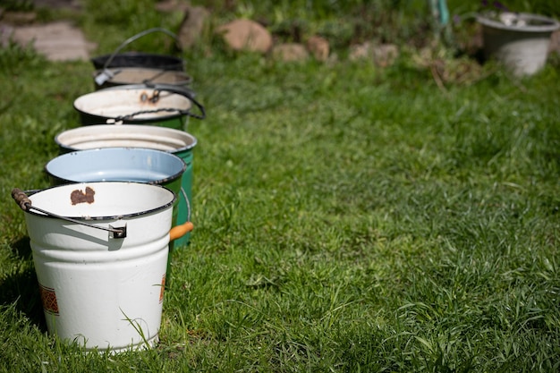 Many different buckets stand in a row to collect rainwater