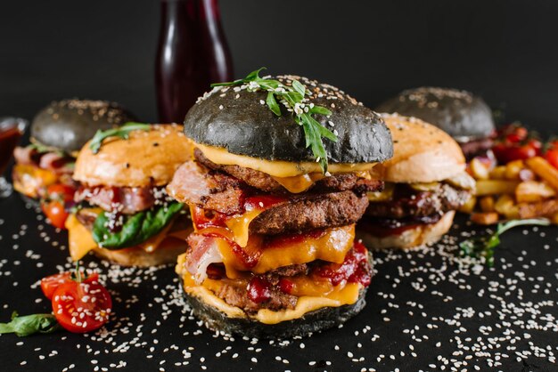 Many different burgers with ingredients on a black background