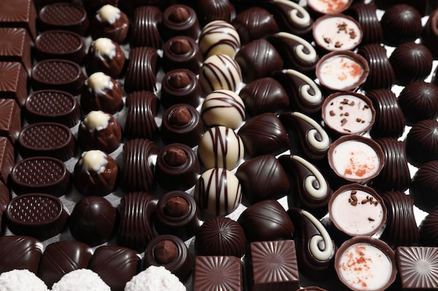 Many different delicious chocolate candies as background closeup view