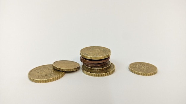 Many different euro coins are stacked in a row on a white background