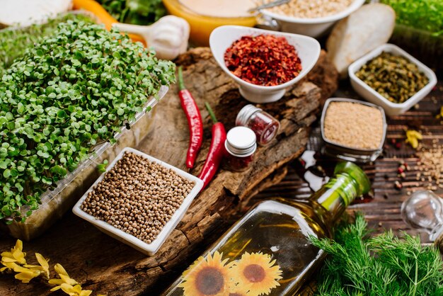 Many different herbs and spices raw and dry with vegetables on wooden background