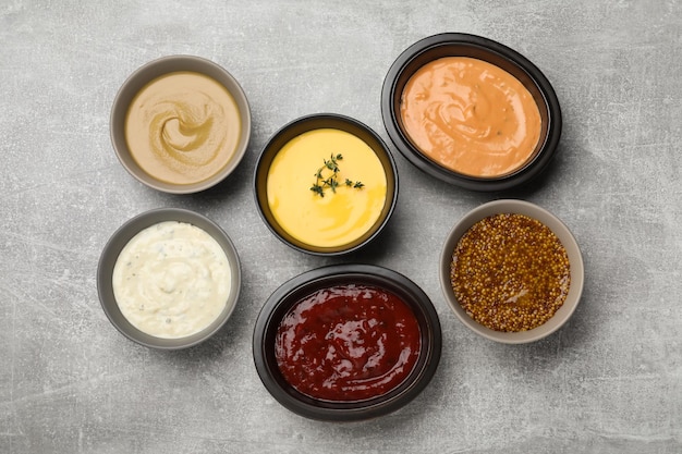 Many different sauces on grey table flat lay