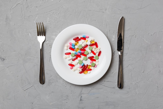 Many different weight loss pills and supplements as food on round plate Pills served as a healthy meal Drugs pharmacy medicine or medical healthycare concept