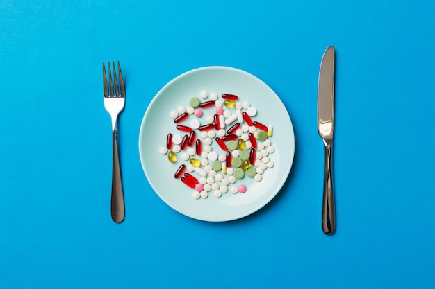 Many different weight loss pills and supplements as food on round plate Pills served as a healthy meal Drugs pharmacy medicine or medical healthycare concept