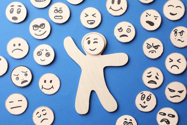 Many faces with different emotions on blue background flat lay