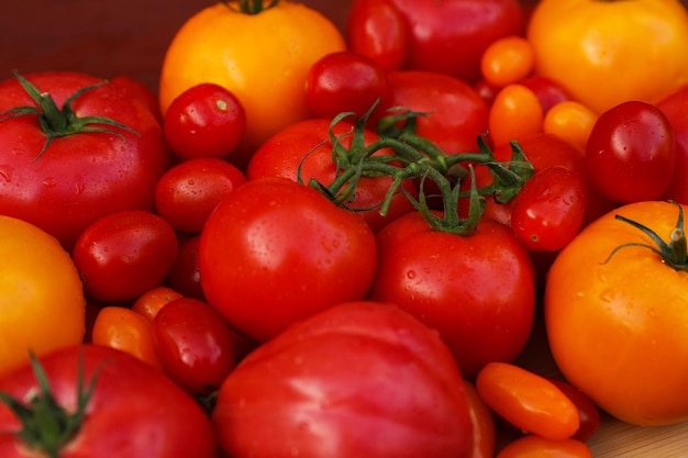 Many fresh tomatoes on wooden surface closeup