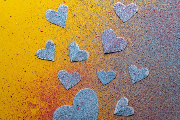 Many hearts symbol of love sprinkled with multicolored bright powder