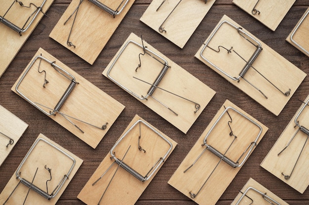 Many mousetraps on the wooden background