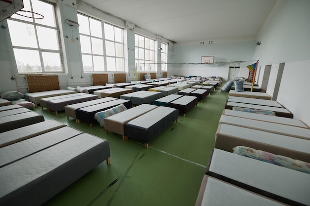 Many multicolored beds with pillows and linens in the interior of the gym