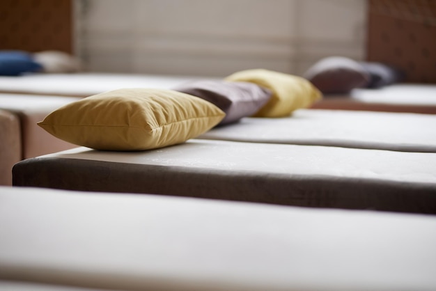 Many multicolored beds with pillows and linens in the interior of the gym