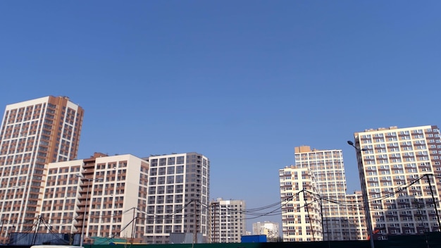 Many new highrise buildings over blue sky background black electrical cable good sunny day