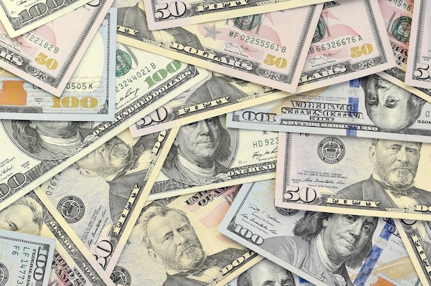 Many one hundred and fifty dollar bills on flat background surface close up Flat lay top view