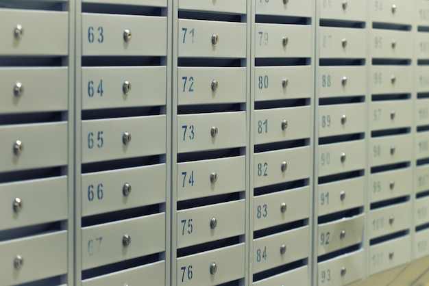 Many posting metal mailboxes with room number at residential building