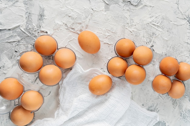 Many raw uncooked chicken eggs in a plastic tray on the grunge table, special egg diets