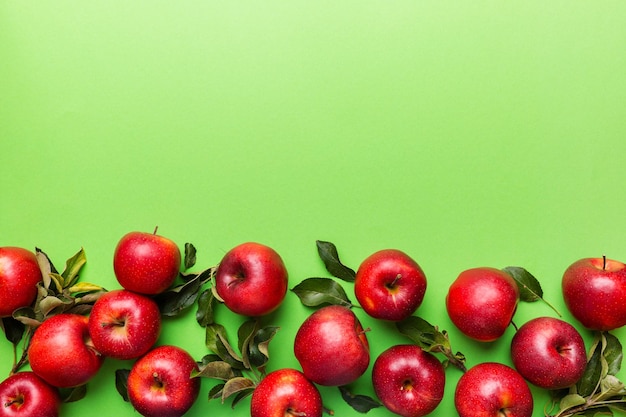 Many red apples on colored background, top view. Autumn pattern with fresh apple above view with copy space for design or text.