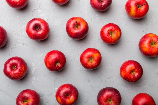 Many red apples on colored background top view Autumn pattern with fresh apple above view