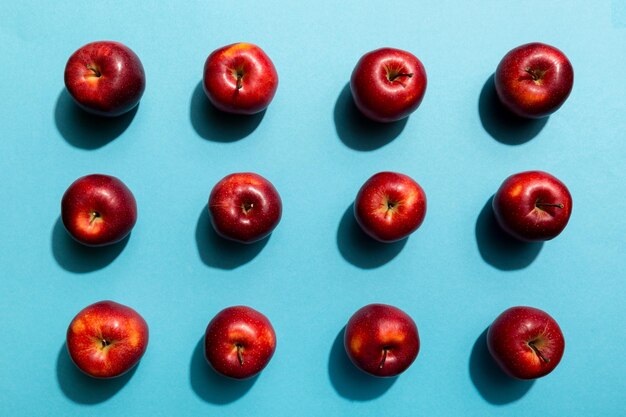 Many red apples on colored background top view Autumn pattern with fresh apple above view