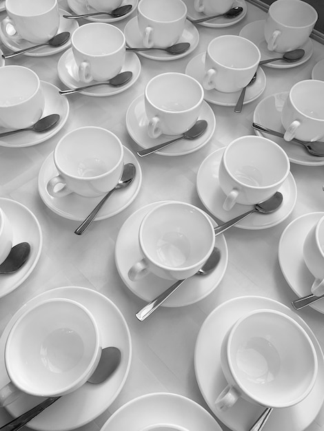 Many rows of white ceramic coffee or tea cups Lines of coffee cups in front of conference room