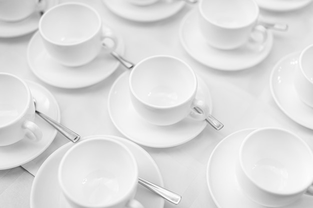 Many rows of white ceramic coffee or tea cups Lines of coffee cups