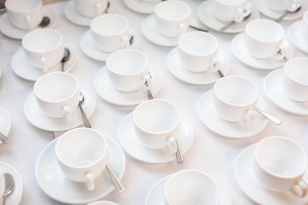 Many rows of white ceramic coffee or tea cups Lines of coffee cups