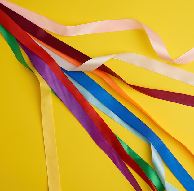 Many silk multi-colored ribbons on yellow