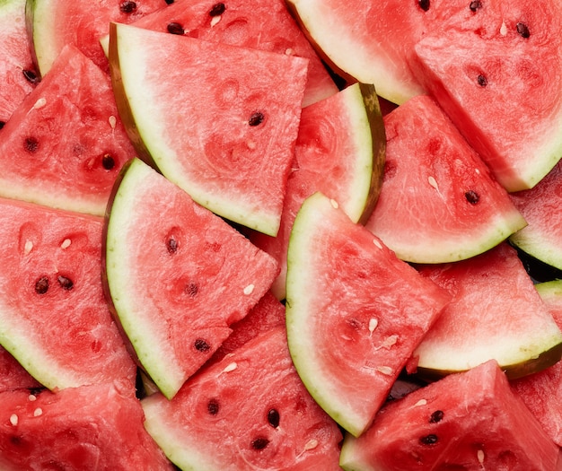 Many sliced terrugol pieces of ripe red watermelon with brown seeds