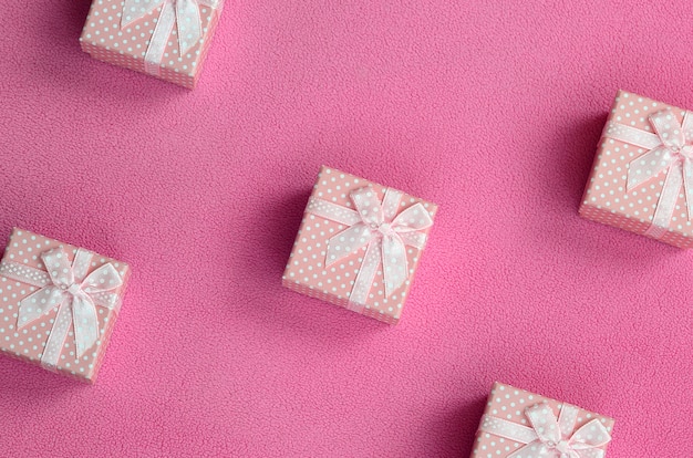 Many small gift boxes in pink color with a small bow