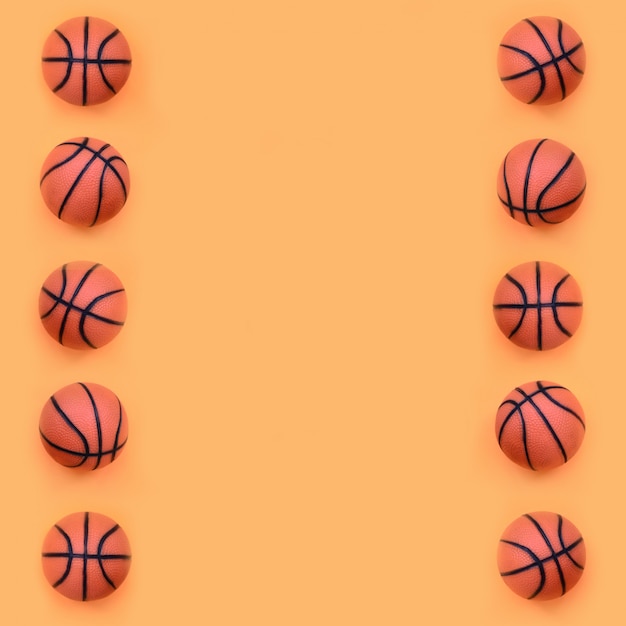 Many small orange balls for basketball sport game lies on fashion pastel orange paper 