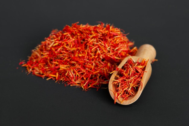 Many spicy saffron spice in the whole background with a wooden spice spatula