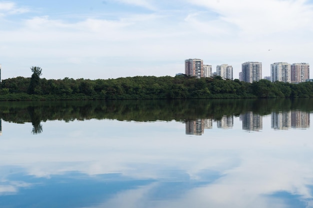 Marapendi Lagoon with buildings vegetation and trees around Hills and Barra da Tijuca bridge in the background Located near Praia da Reserva in Rio de Janeiro