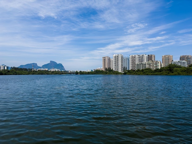 Marapendi Lagoon with buildings vegetation and trees around Hills and Barra da Tijuca bridge in the background Located near Praia da Reserva in Rio de Janeiro