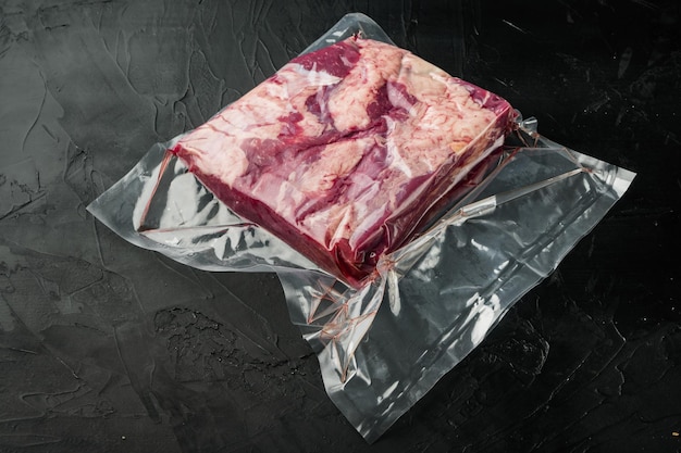 Marble beef in vacuum packed on black stone background with copyspace and space for text