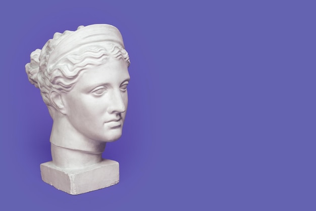 Marble head of young woman ancient Greek goddess bust isolated on violet background very peri color of 2022 year