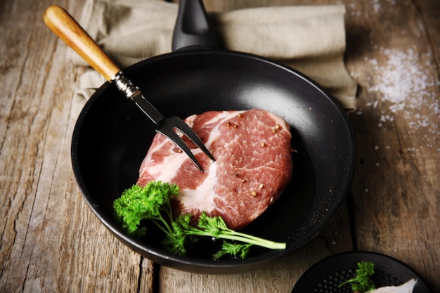 Marbled beef steak on pan and spices on wooden background