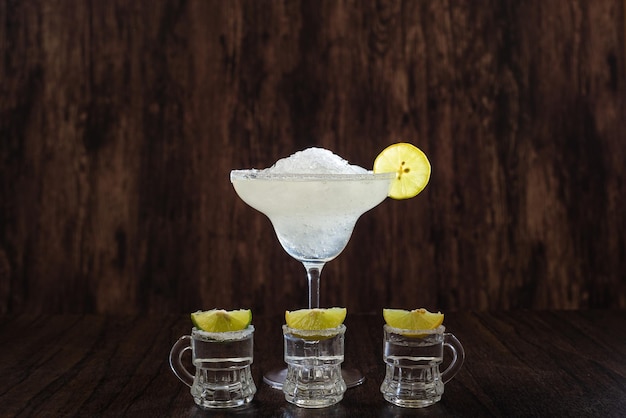 Margarita cocktail and tequila shots with lime and salt on a dark background Mexican drinks