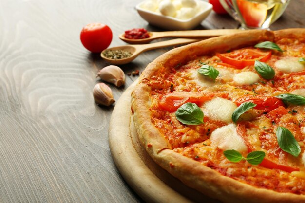 Margherita pizza with tomatoes garlic spices and Mozzarella on wooden background