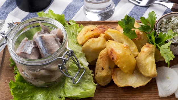 Marinated herring in a jar with onion fried potatoes sandwiches of caviar of a capelin and sauce