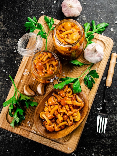 Marinated mushrooms with parsley on a wooden cutting board