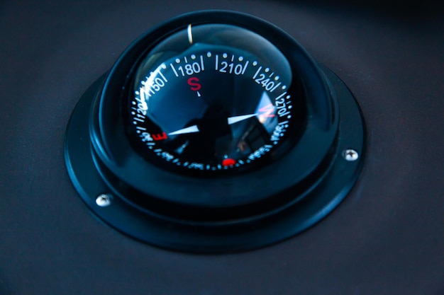 Marine gyrocompass mounted on the black hull of the yacht closeup Yacht navigation equipment