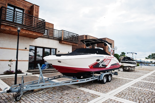 Marine parking of modern motor boats. Luxury yacht on a car trailer.