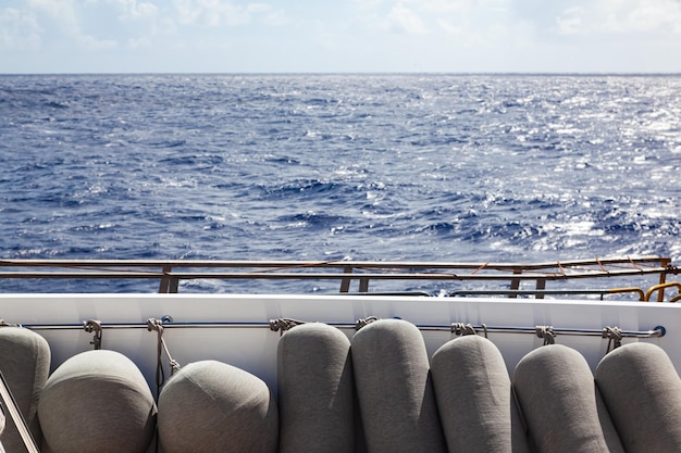 Marine yacht fenders stacked and tied on the deck of the yacht against the backdrop of the sea