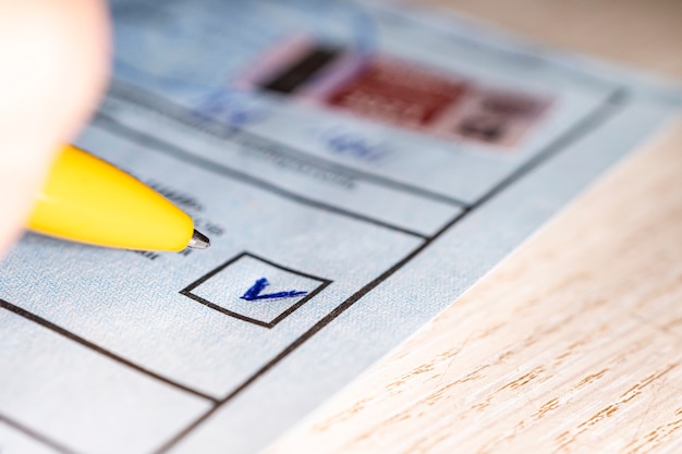 Photo mark in square on the electoral ticket. choice of a political party to vote on. mark in the selection and a close-up pen. presidential or parliamentary elections in the country. concept of choice.