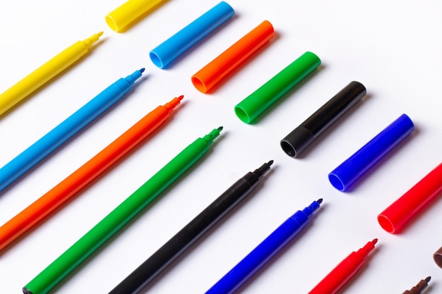 Markers of different colors at an angle on a white background caps separately