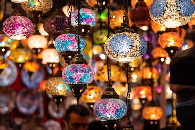 A market stall with colorful lights and a man looking at them.