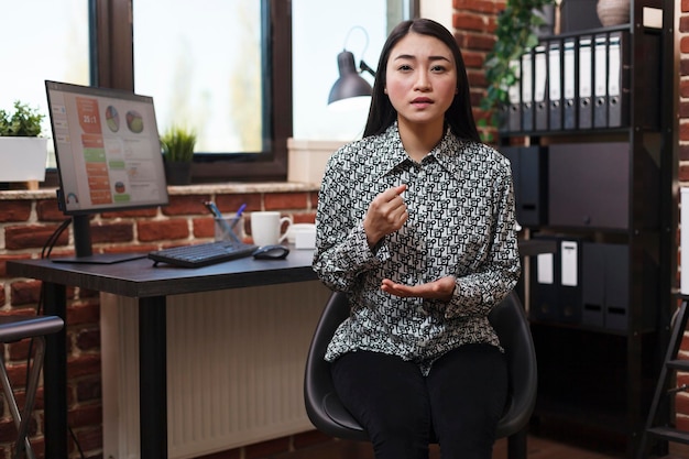 Marketing company worker in online remote chat, hand gesturing and talking about bad work results. Good looking productive asian businesswoman in video call conference explaining business plan.